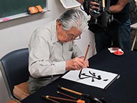 揮毫される小久保先生